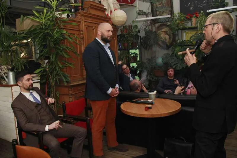 Шарль д’Анжу (стоїть в центрі) розповідає про подорож на Донбас у Московському сигарному клубі у квітні 2022 року